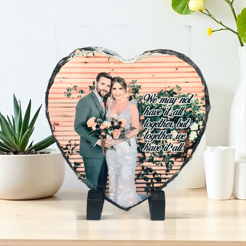 Custom heart photo rock slate displaying a wedding picture on a black easel stand.