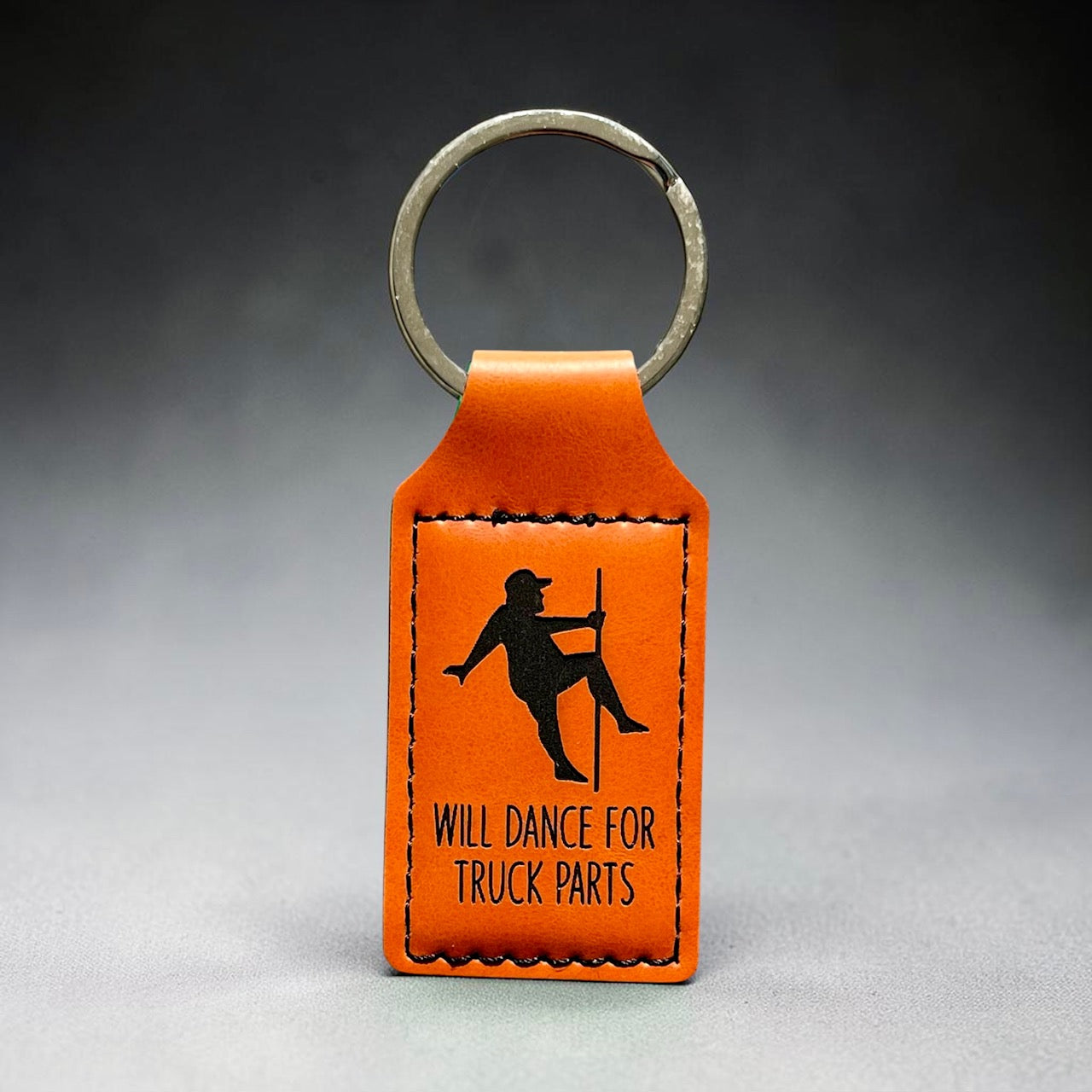Front view of a Premium Leatherette keychain laser engraved with the quote will dance for truck parts.