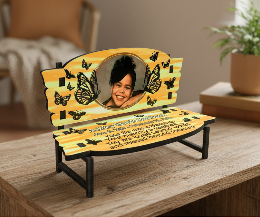 Side view of a personalized wooden miniature memorial bench photo display standing on a flat surface.